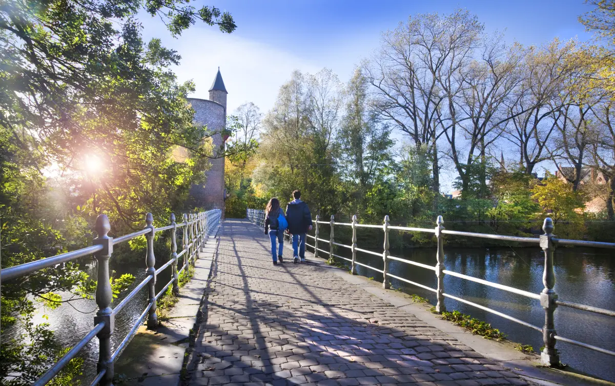 Two visitors walking over Lovers' Bridge towards Gunpowder Tower