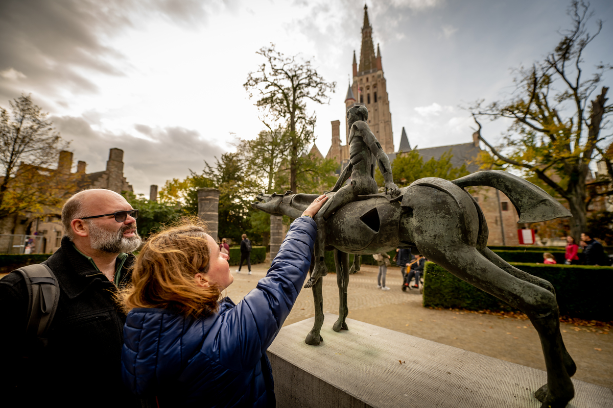 Blind woman feeling a metal rider statue from the sculpture group 'The Four Horsemen of the Apocalypse' at Hof Arents